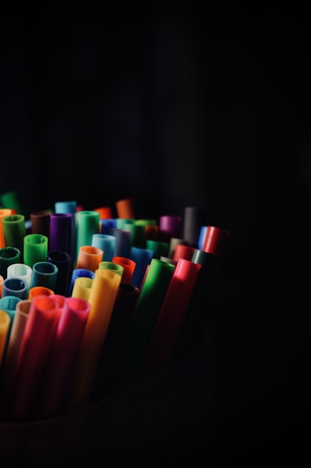 Close-up of vibrant artistic markers and brushes in a lively, colorful setting