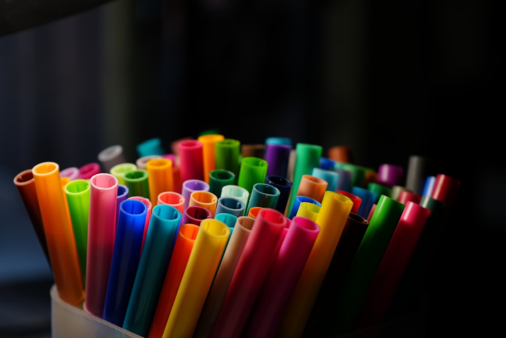 a cup filled with lots of different colored straws