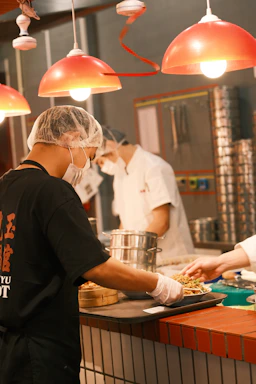 Photo of a food safety professional inspecting a commercial kitchen with a checklist and safety gear.