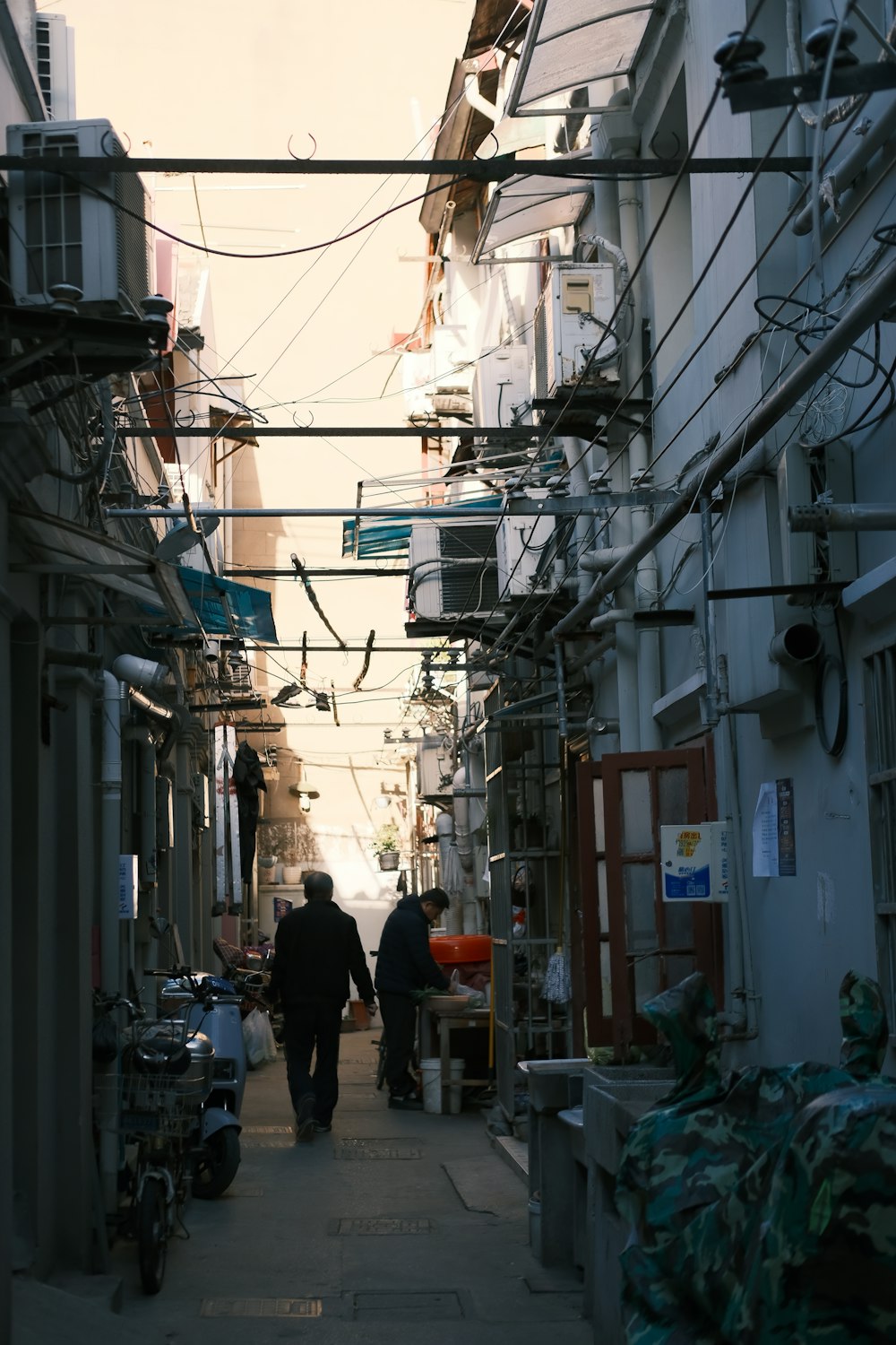 two people walking down a narrow alley way