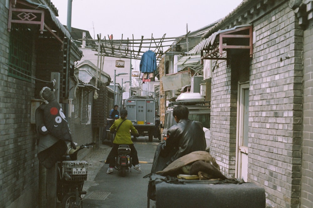 a couple of people walking down a narrow alley way