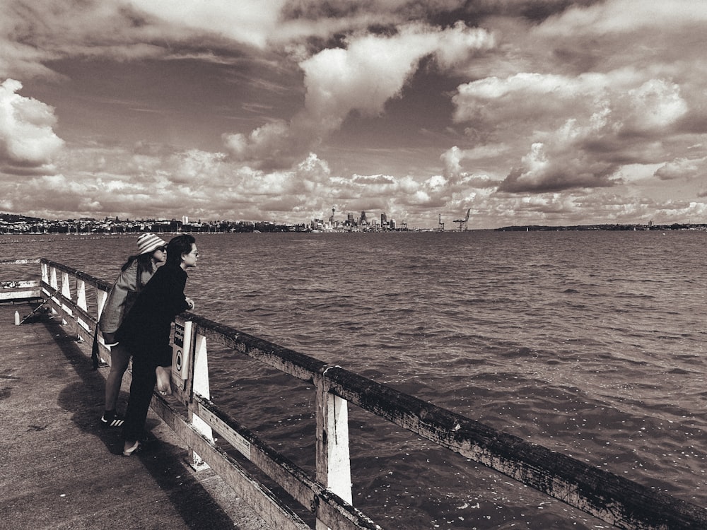 a person standing on a pier with an umbrella