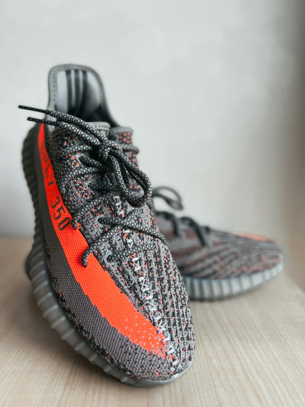 a pair of grey and orange sneakers on a table