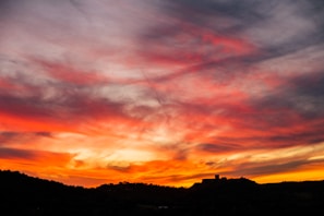A vibrant sunset over the iconic Cinderella Castle at Disney World, with joyful families in the foreground.