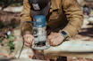 A craftsman using a tablet on a construction site with a clear blue sky background