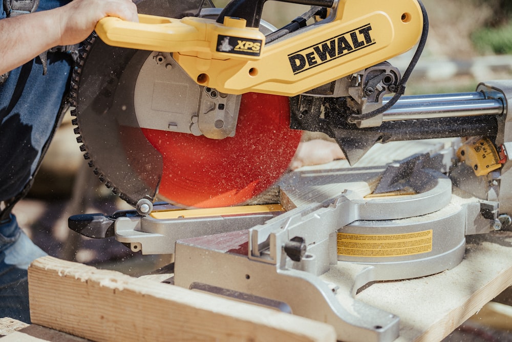 a man using a circular saw to cut a piece of wood