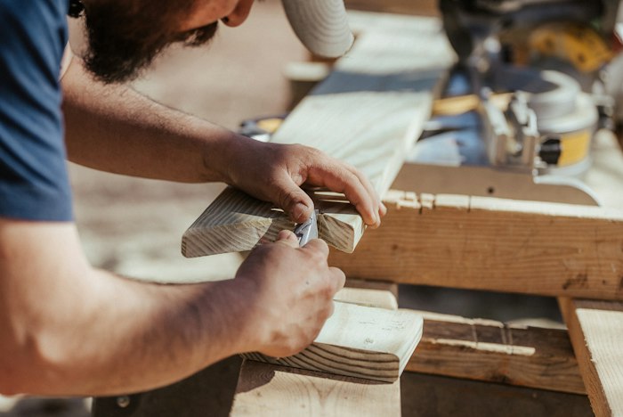 Carpenter assembling kitchen cabinet in workshop