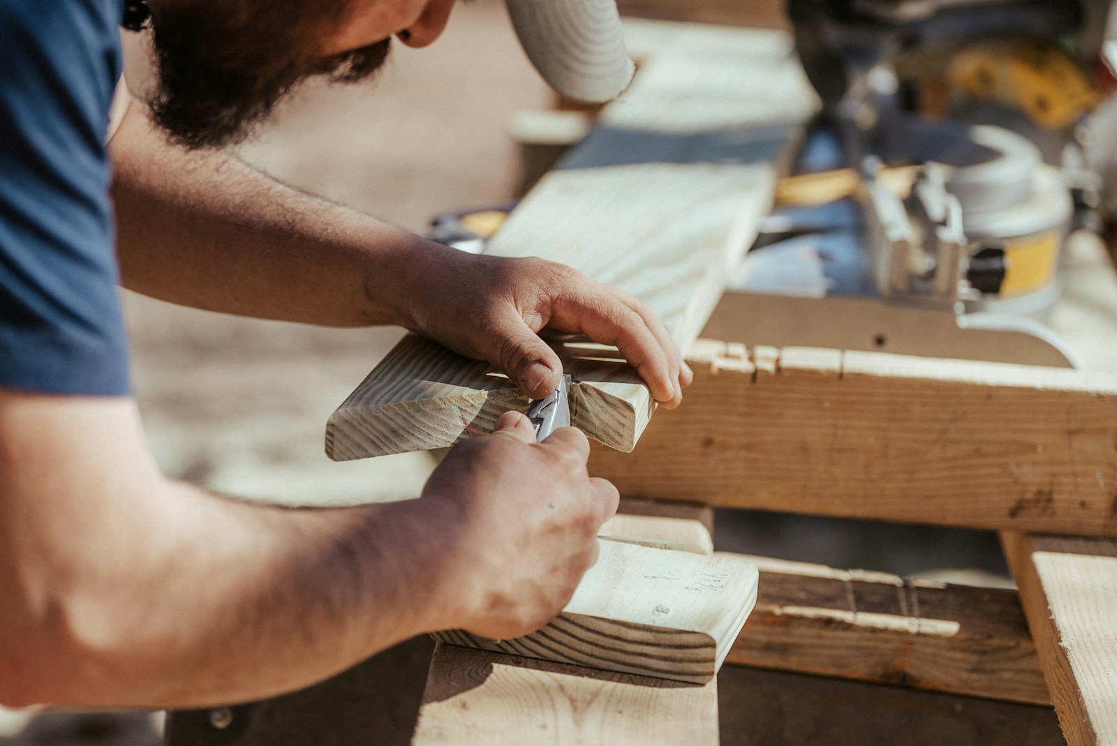 Artisan menuisier travaillant sur une pièce en bois — entreprise bâtiment France BTP