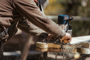 a man sanding a piece of wood with a sander