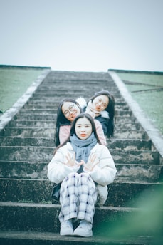 three girls sitting on a set of stairs