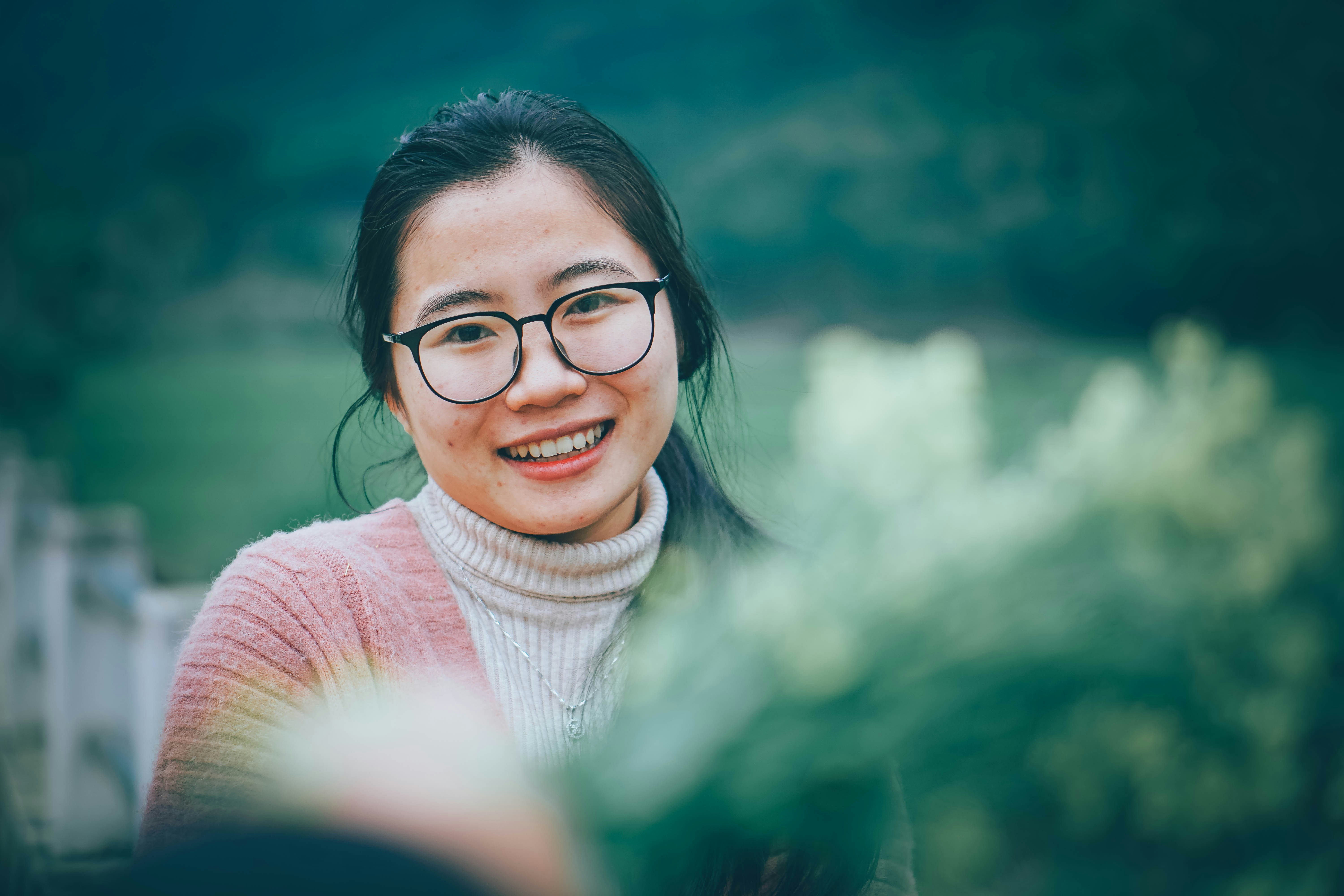 A woman wearing glasses smiling at the camera photo – Free Person Image ...