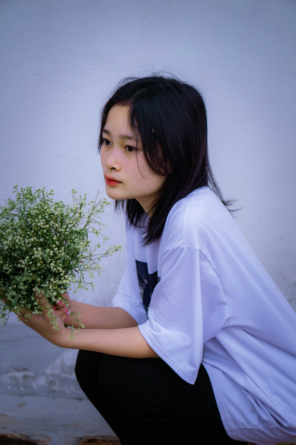 a woman kneeling down holding a bouquet of flowers