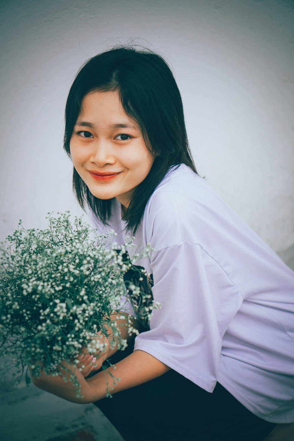 a woman holding a bouquet of flowers in her hands