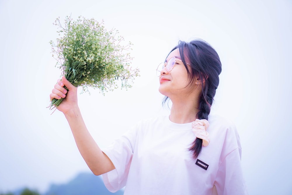 a woman holding a bunch of flowers in her hand