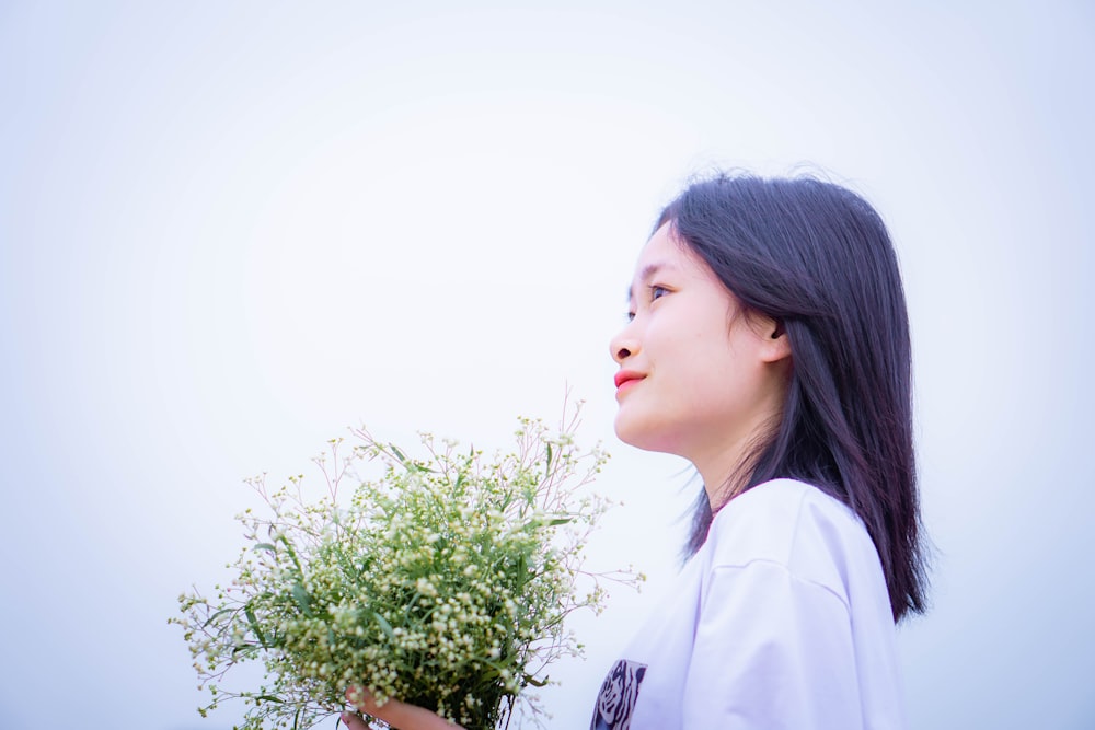 a woman holding a bouquet of flowers in her hands