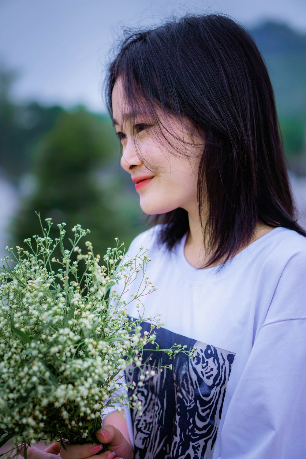 a woman holding a plant in her hands