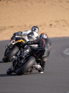 Riders in full safety gear enjoying a high-speed turn on the track.