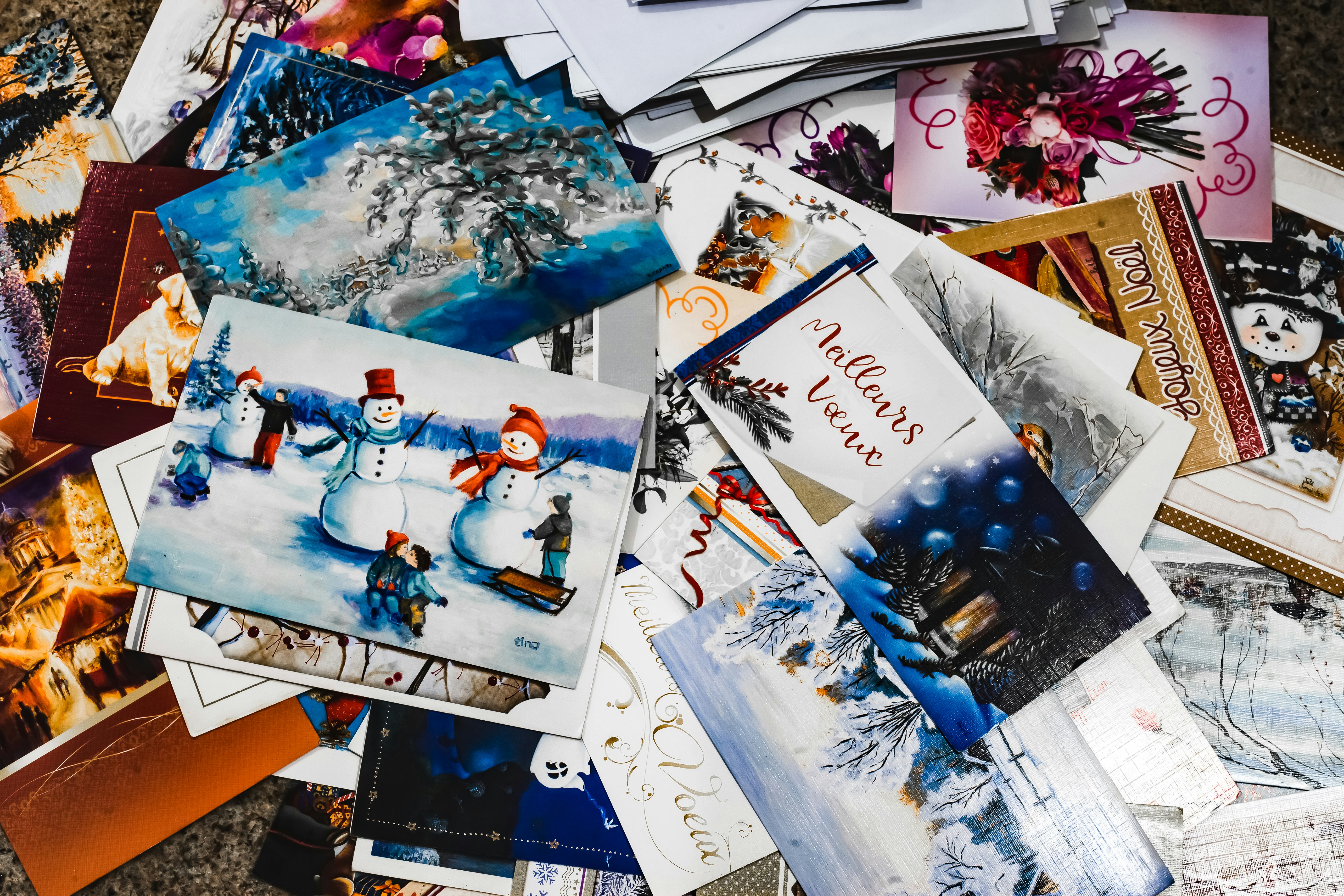 Stack of Christmas greeting cards with winter scenes and holiday messages