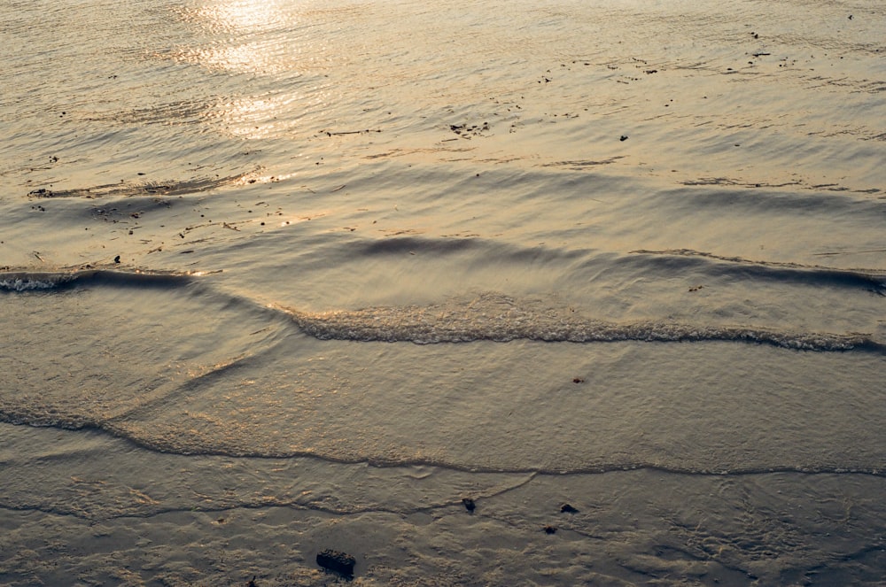 a sandy beach with waves coming in to shore