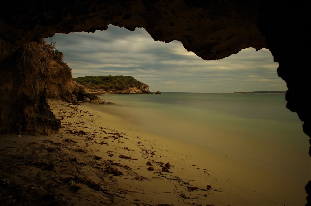 a view of a beach through a cave