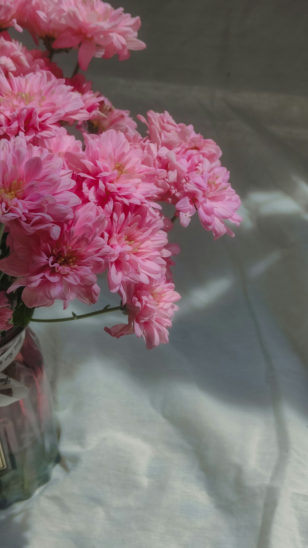 a glass vase filled with pink flowers on a table