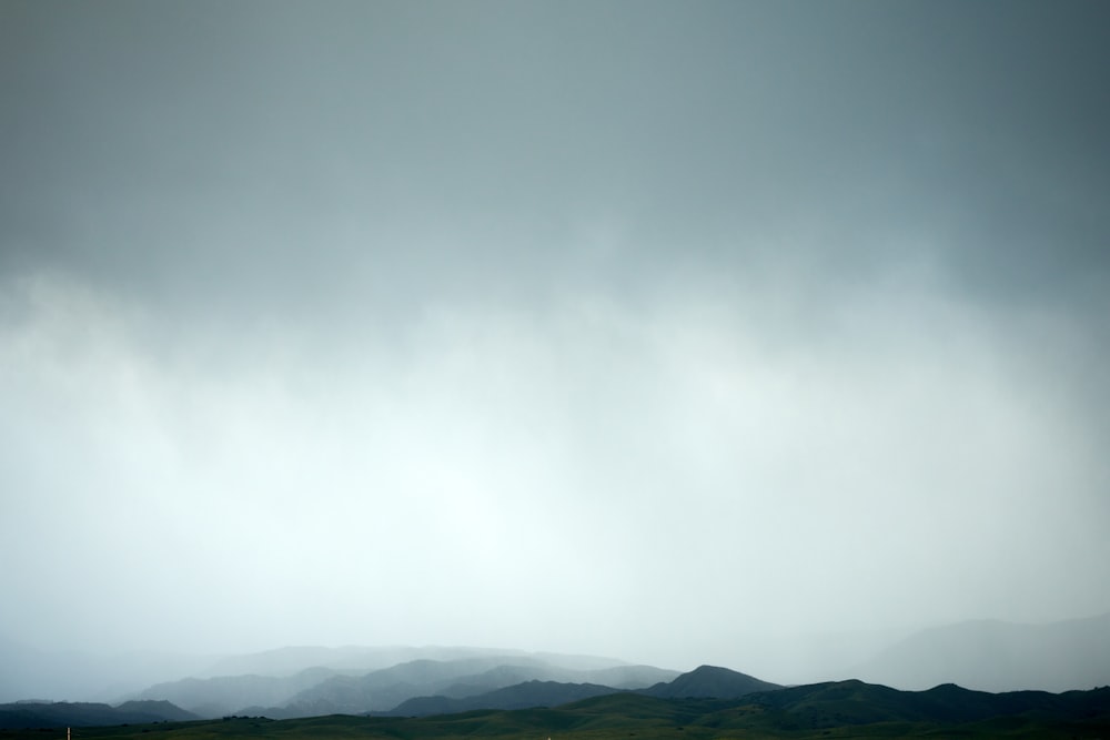 a view of a field with mountains in the distance