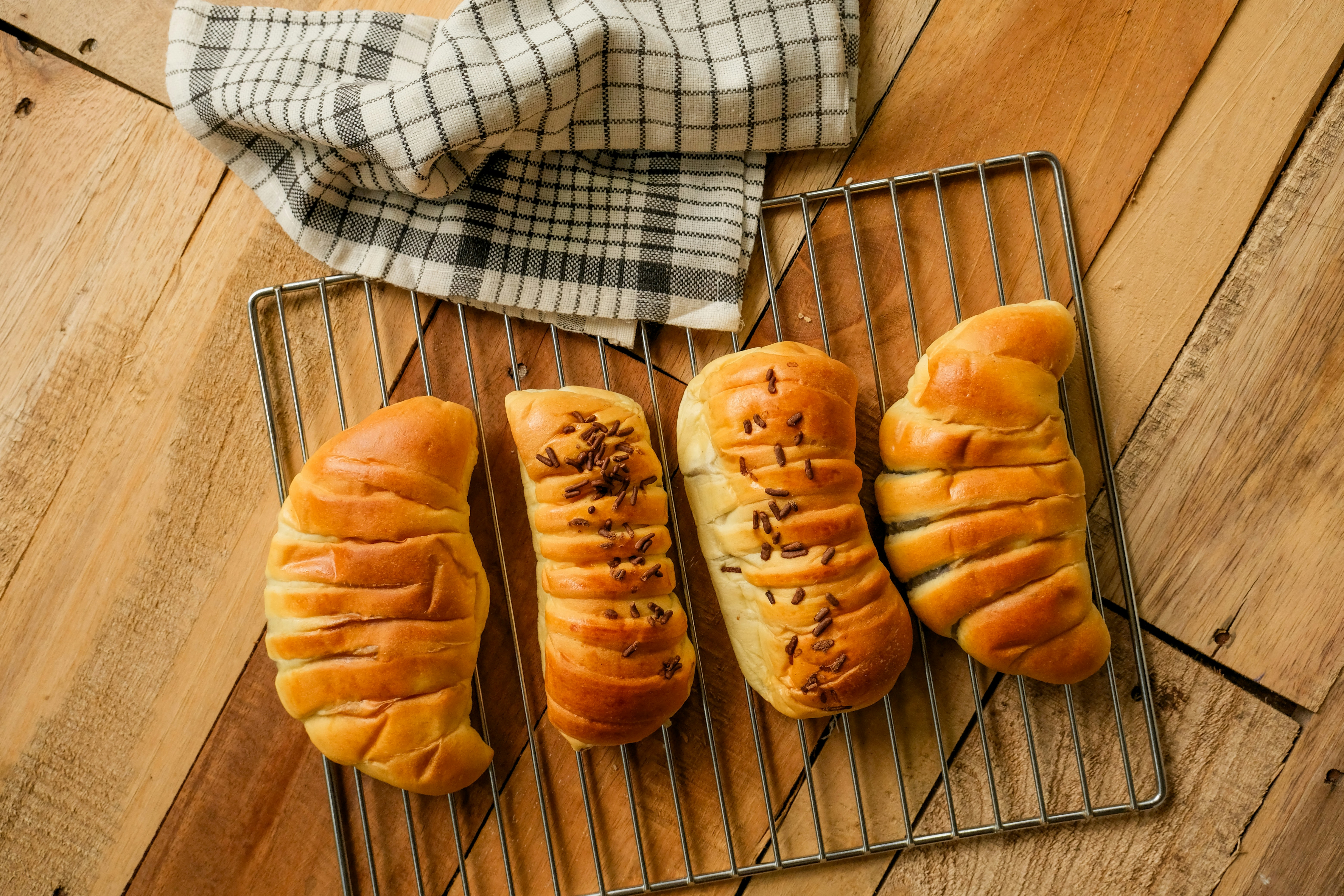 a group of breads sitting on top of a metal rack