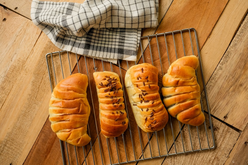 a group of breads sitting on top of a metal rack