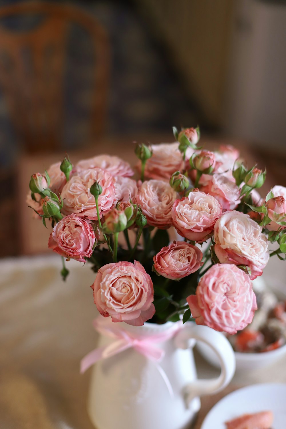 a vase of pink roses on a table