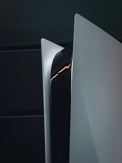 A sleek black gaming console with glowing orange and red accents on a dark background.