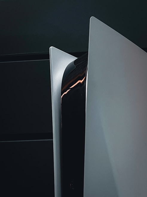 A sleek, modern gaming console with a white and black design, featuring sharp angles and a glossy finish.