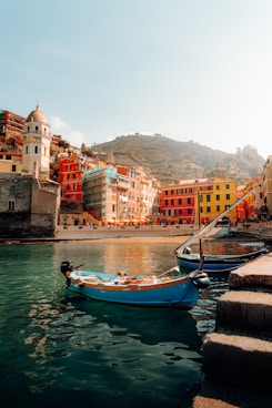 a small boat in the water next to a city