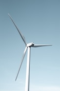 A wind turbine spinning against a clear blue sky.
