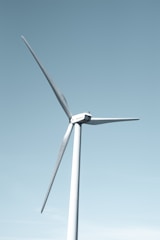A wind farm with turbines against a clear blue sky.