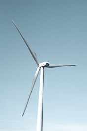A wind farm with turbines spinning against a clear blue sky.