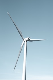 A wind farm with turbines generating renewable energy against a clear blue sky.