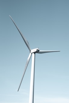A wind farm with several turbines set against a clear blue sky.