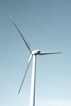 A wind farm with turbines against a clear blue sky.