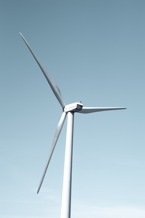 A modern wind turbine set against a clear blue sky.