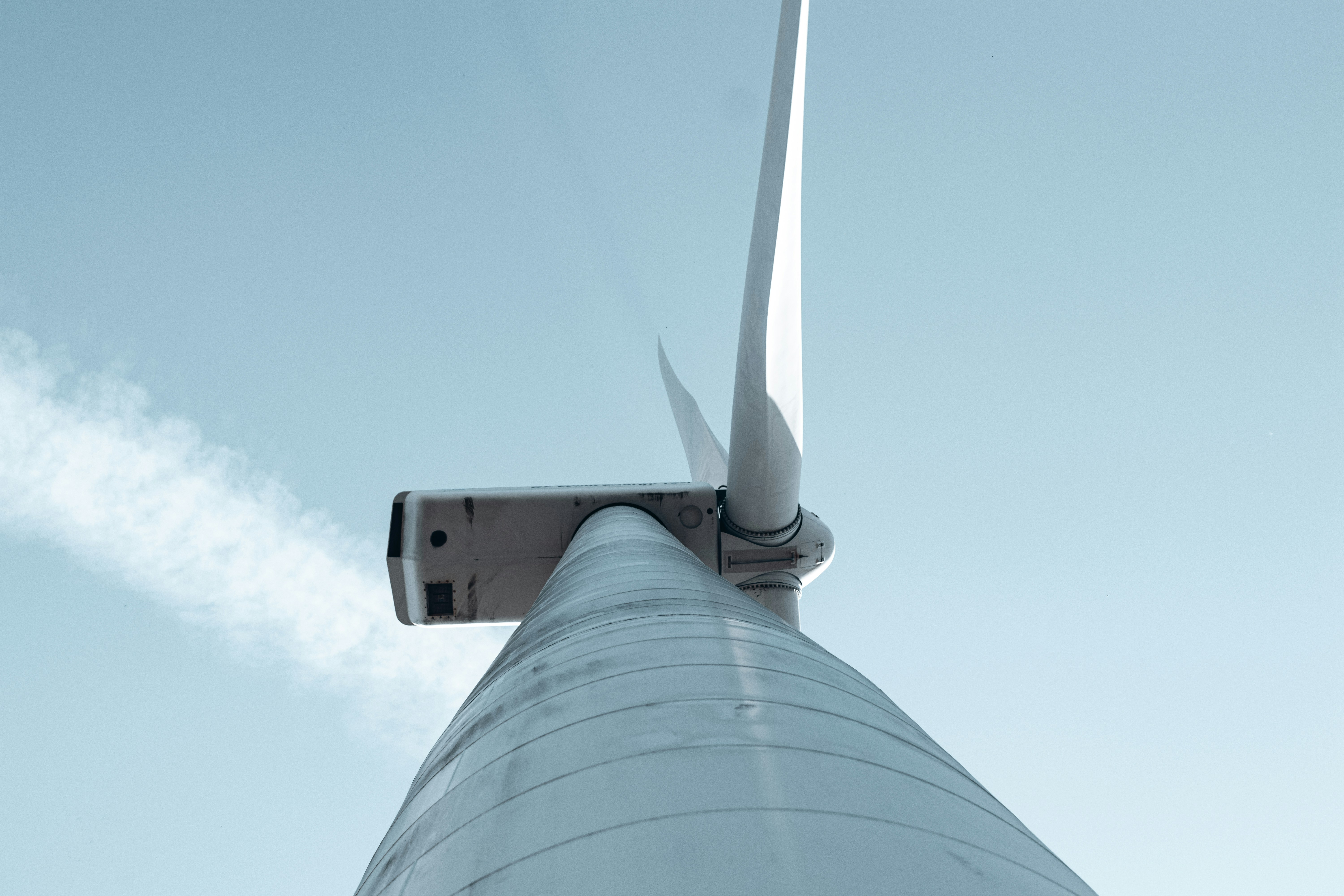 A close up of a wind turbine against a blue sky photo – Free Wind ...