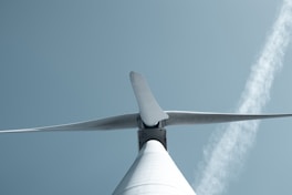 a close up of a wind turbine with a sky background
