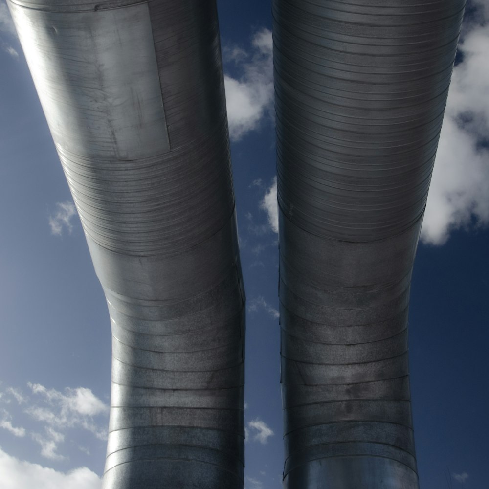 a couple of large metal pipes sitting under a cloudy blue sky