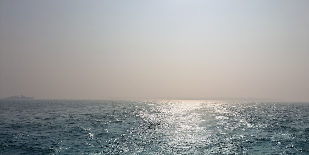 a large body of water with a boat in the distance