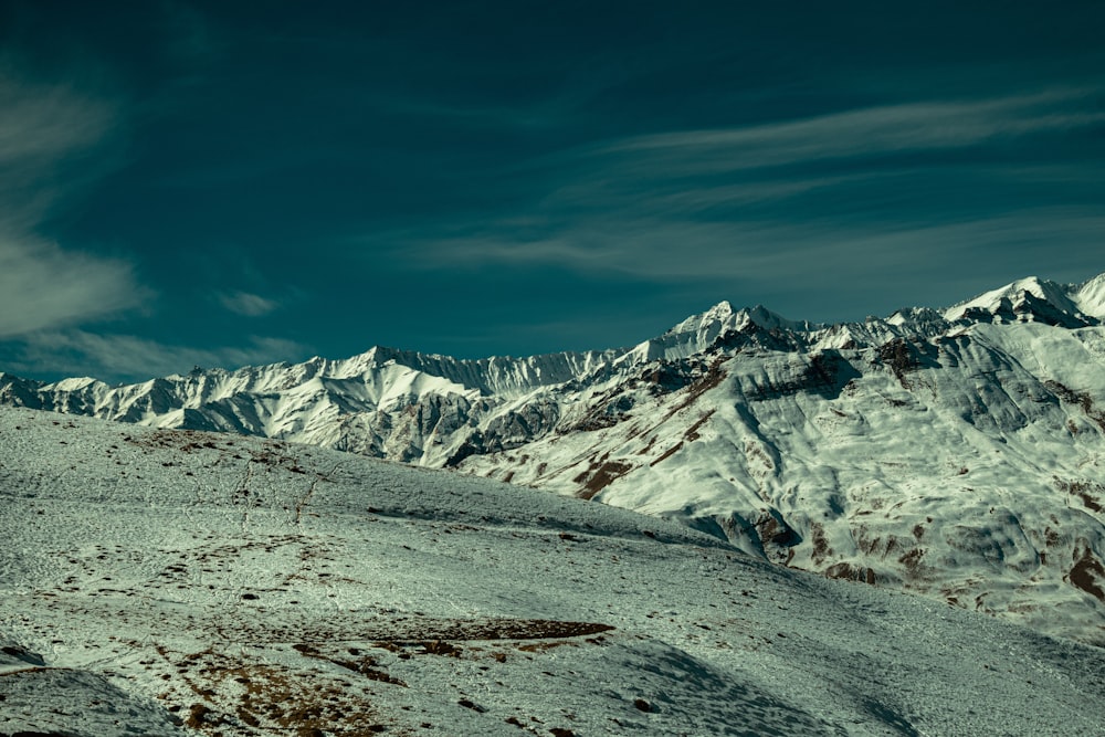 a man riding a snowboard down the side of a snow covered slope