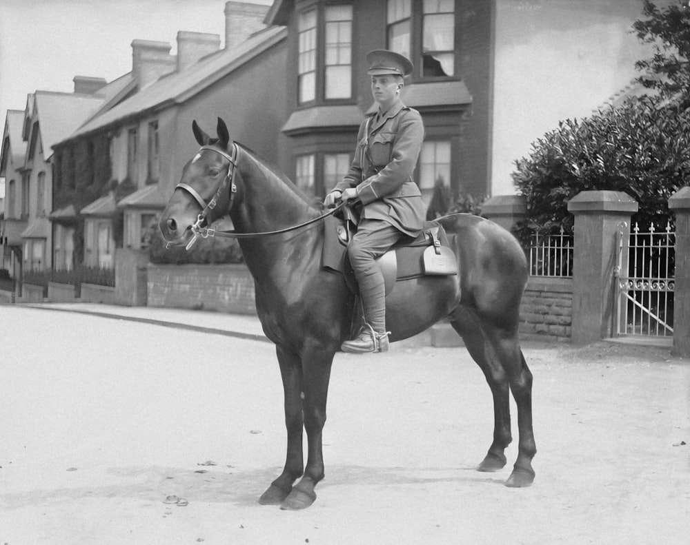a black and white photo of a man on a horse