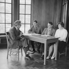 a group of people sitting around a wooden table