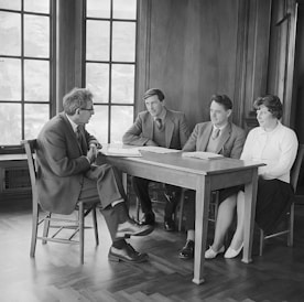 a group of people sitting around a wooden table