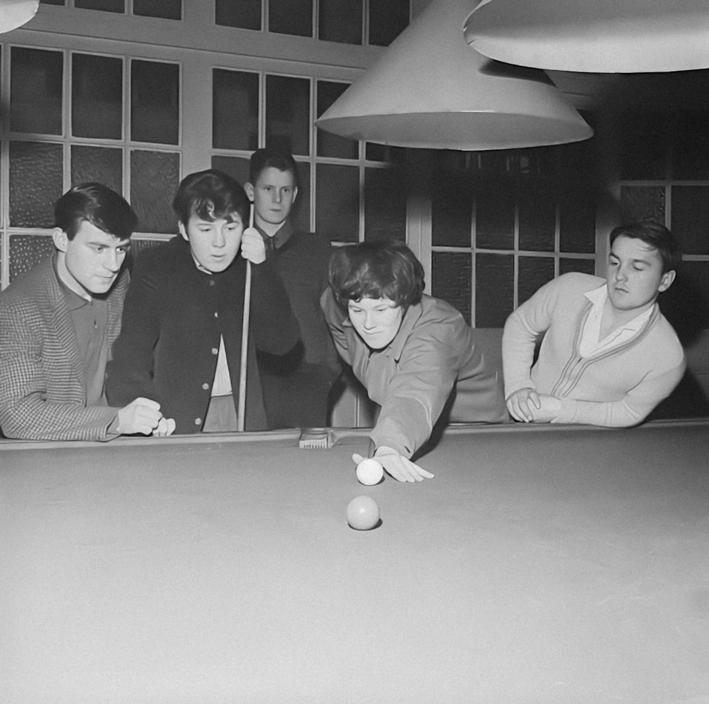 a group of people playing a game of pool