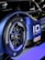 A close-up of a car's rear wheel featuring Bridgestone Potenza tires. The car has a sleek, modern design with a blue and black color scheme. The logo and branding for Volkswagen ID and Castrol are visible, suggesting it is a high-performance electric vehicle.