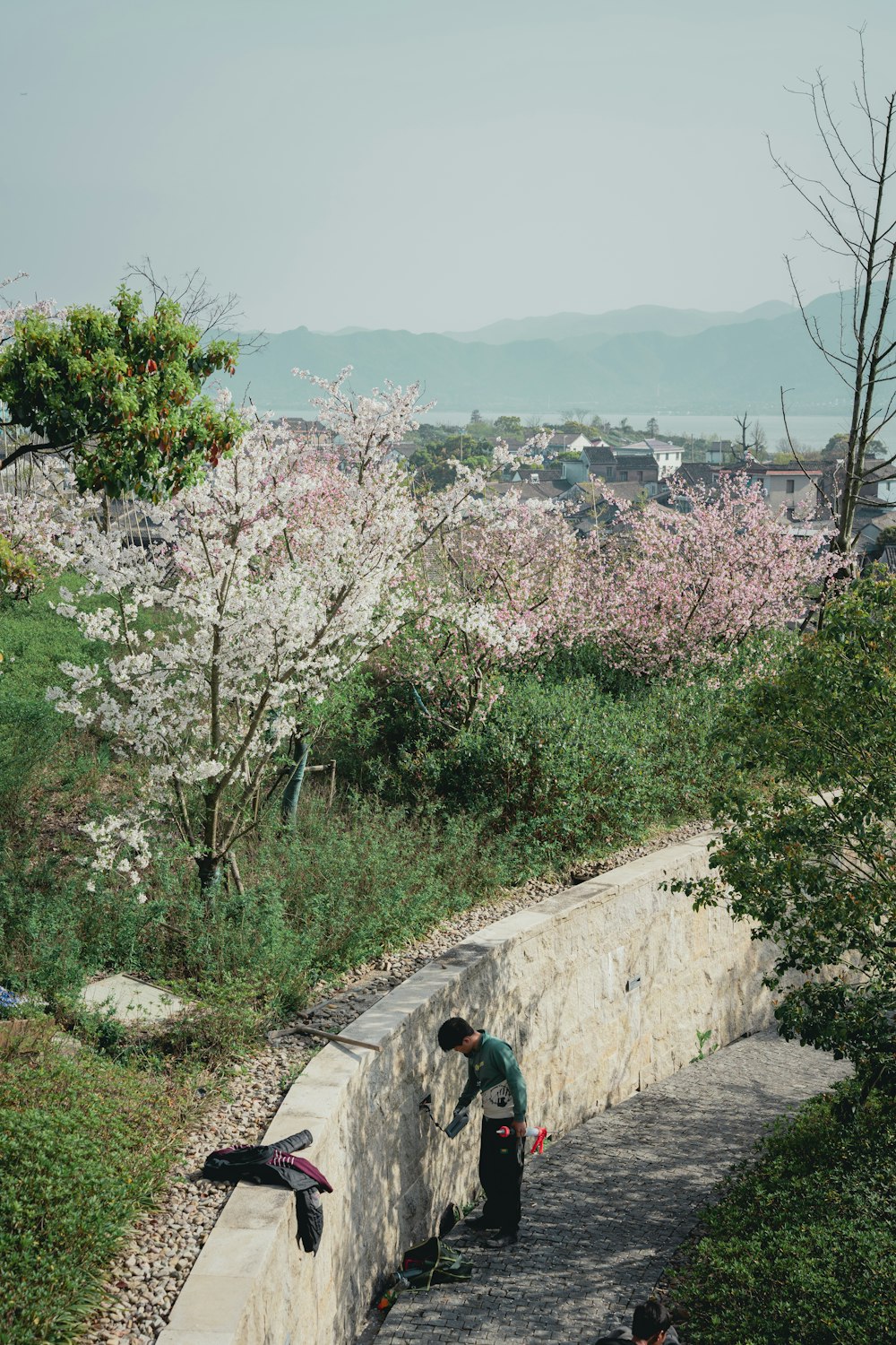 a man standing next to a stone wall